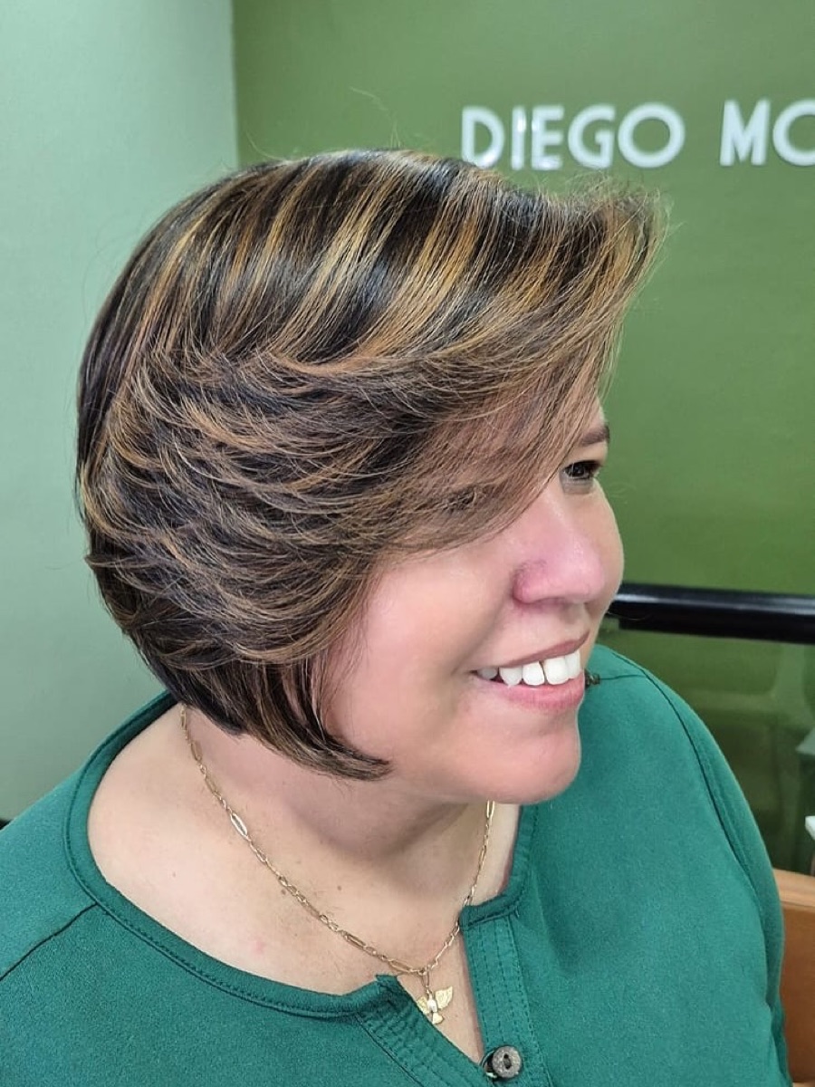 Corte bob curto com luzes, perfil da cliente sorrindo no salão